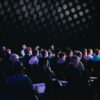 crowd of people sitting on chairs inside room