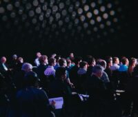 crowd of people sitting on chairs inside room